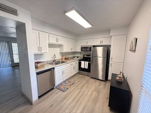 A kitchen with white cabinets and stainless steel appliances.