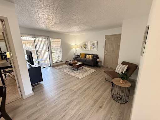 A living room with a grey couch and a wooden floor.