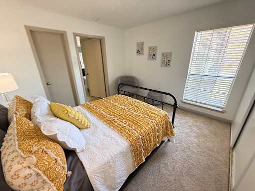 A bedroom with a bed, pillow, and blanket.