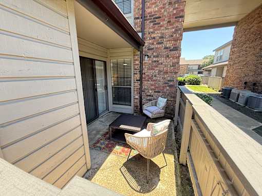 A balcony with a chair and table.