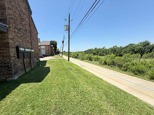 A grassy area with a road and a building on the left.