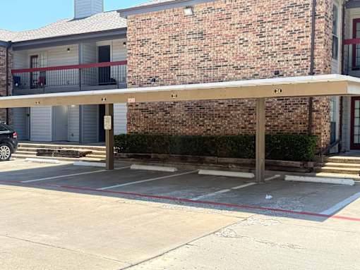 A parking lot with a brick building in the background.