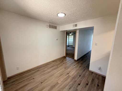 A room with wooden flooring and a white ceiling.