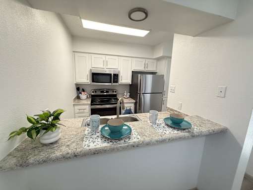 A kitchen with a granite countertop and stainless steel appliances.