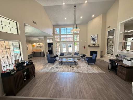A spacious living room with a large window and a fireplace.