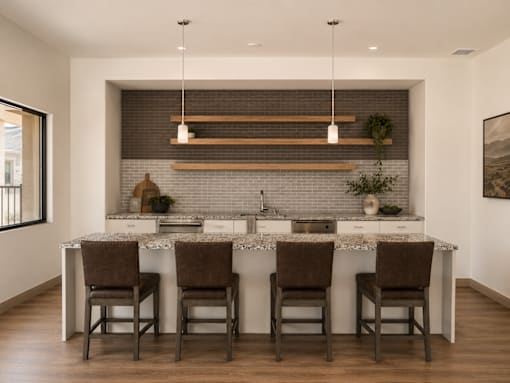 A kitchen with a white countertop and brown chairs.