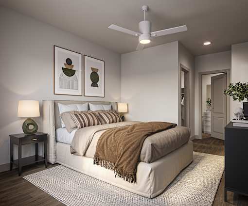 A bedroom with a large bed and a ceiling fan.