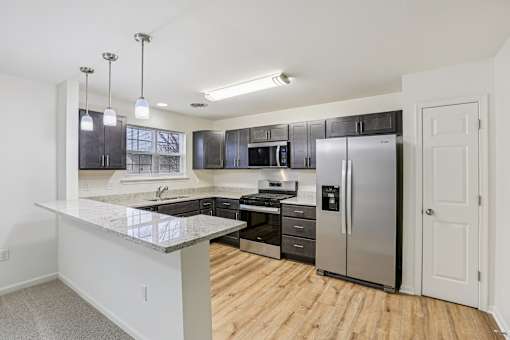 A kitchen with a refrigerator, stove, and oven.