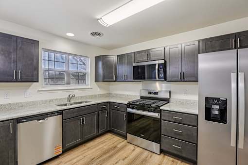 A kitchen with dark wood cabinets and stainless steel appliances.