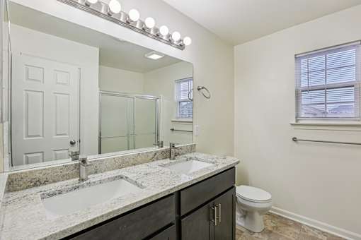 A bathroom with a marble countertop and a white toilet.