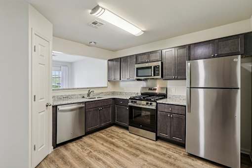 A kitchen with a stainless steel refrigerator, oven, and microwave.