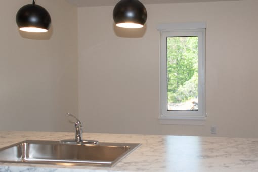 an empty kitchen with a sink and a window