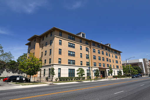 A large apartment building with a parking lot in front.