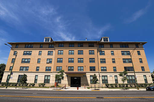 A large building with a flat roof and a red door in front.