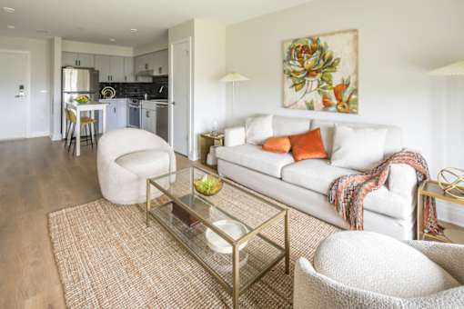 A modern living room with a white couch and a glass coffee table.