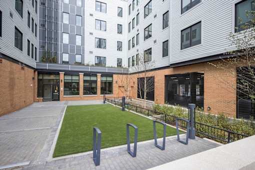 A modern building with a brick facade and a green lawn in front.