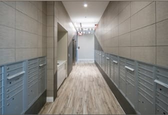A long hallway with wood floors and grey walls.