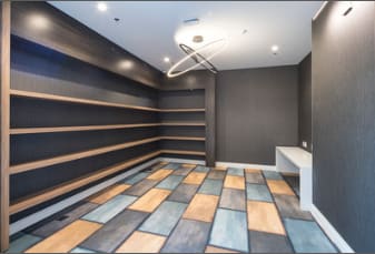 A room with a wooden floor and a white bench.
