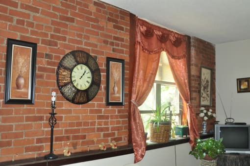 a brick wall with a clock on it next to a window