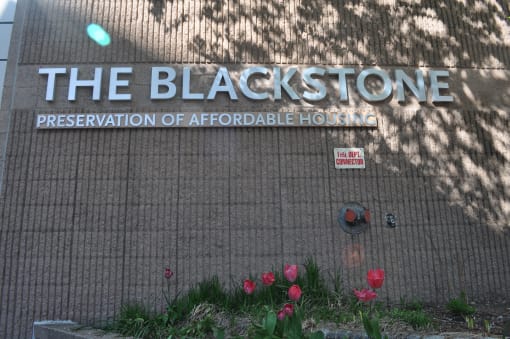 a sign for the blackstone preservation of affordable housing on the side of a building