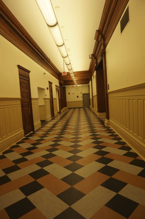 an empty hallway in a building with a checkered floor
