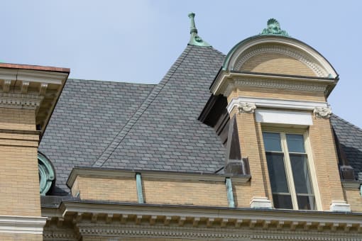 the roof of a brick building with a steeple and a window