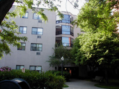 an apartment building with trees in front of it