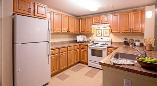 A kitchen with wooden cabinets and a white refrigerator.
