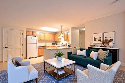 A modern living room with a kitchen in the background.