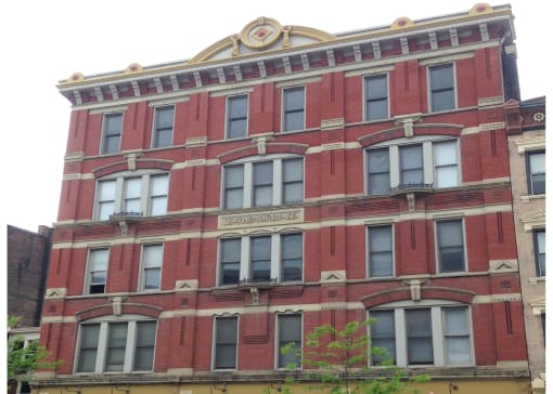 the front of a red brick building with many windows