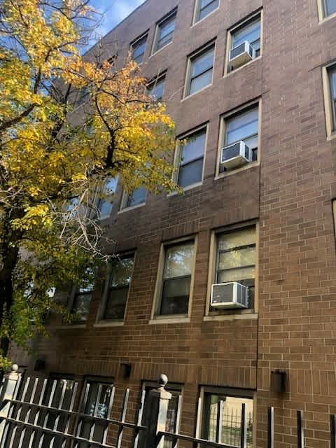 A brown building with a tree in front of it.
