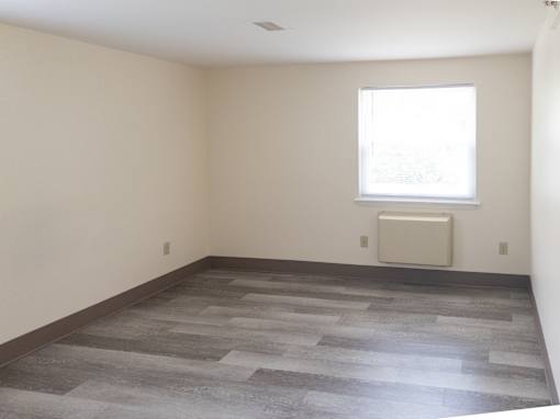 A room with a window and a radiator on the wall.