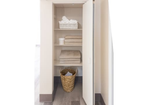 A white refrigerator with a basket on the floor.