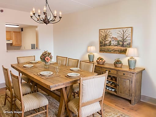 A dining room with a wooden table and chairs.