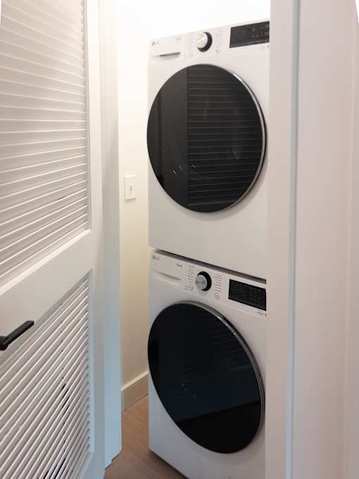 A white front loading washing machine in a laundry room.