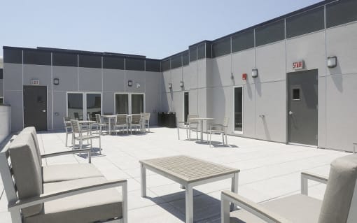 a patio area with tables and chairs in front of a building