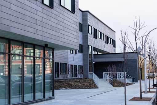 A modern building with a grey exterior and a glass entrance.