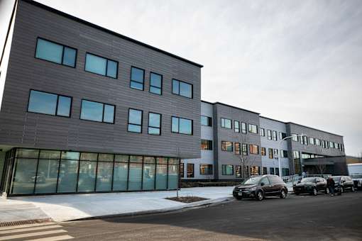 A modern building with a parking lot in front.