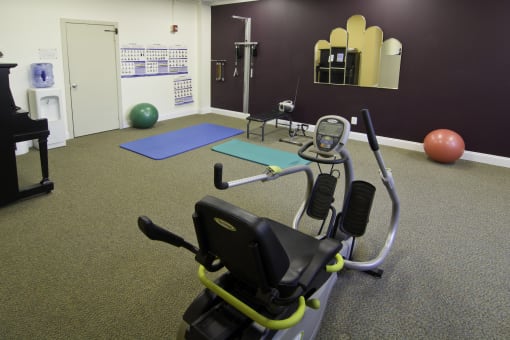 a gym with an exercise bike and a yoga exercise ball