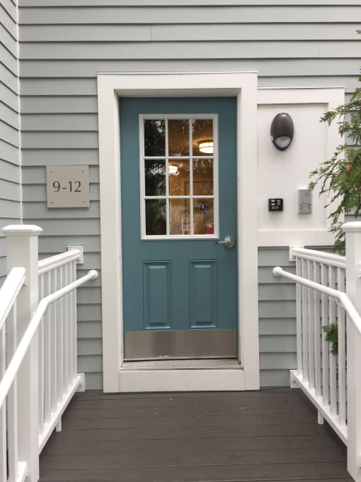 a tiny house with a blue door and a staircase