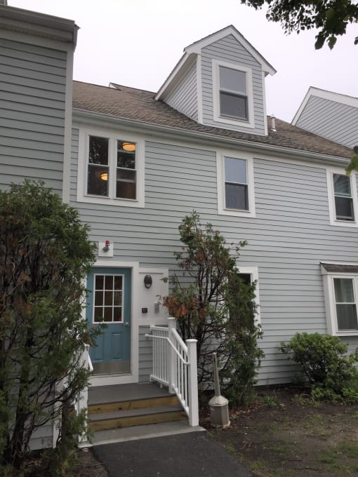the front of the house with a blue door