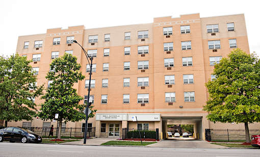 A large brick building with a black fence in front.