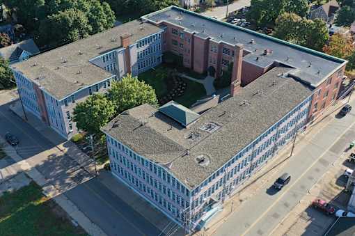 an aerial view of a building with a gray roof