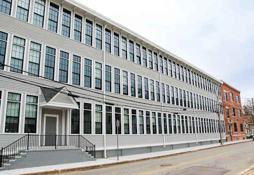 A grey building with a black railing in front.