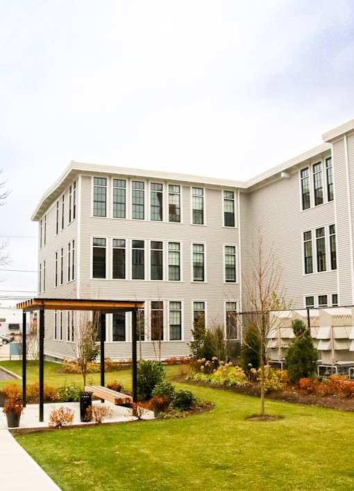 A modern building with a green lawn in front.