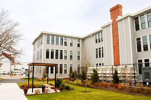 A building with a red brick chimney and a covered walkway.