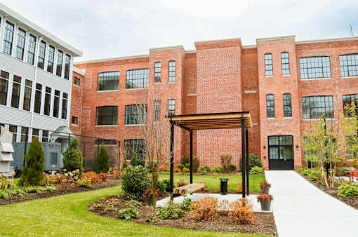 A red brick building with a walkway in front of it.