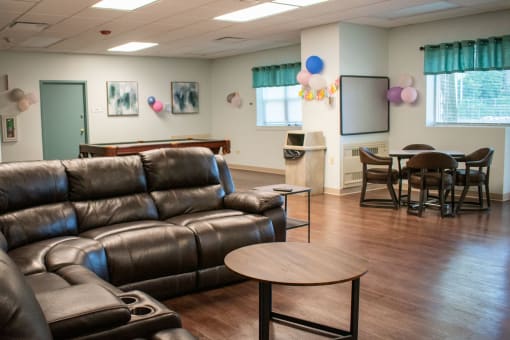a living room with couches and a table and chairs and a projection screen