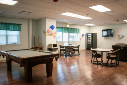 an empty game room with a pool table and tables