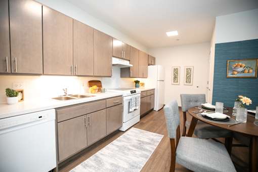 A modern kitchen with a dining table set for two.